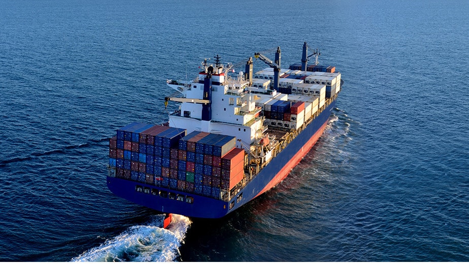 Freight ship on the ocean. A device management tool is used to monitor the goods remotely.